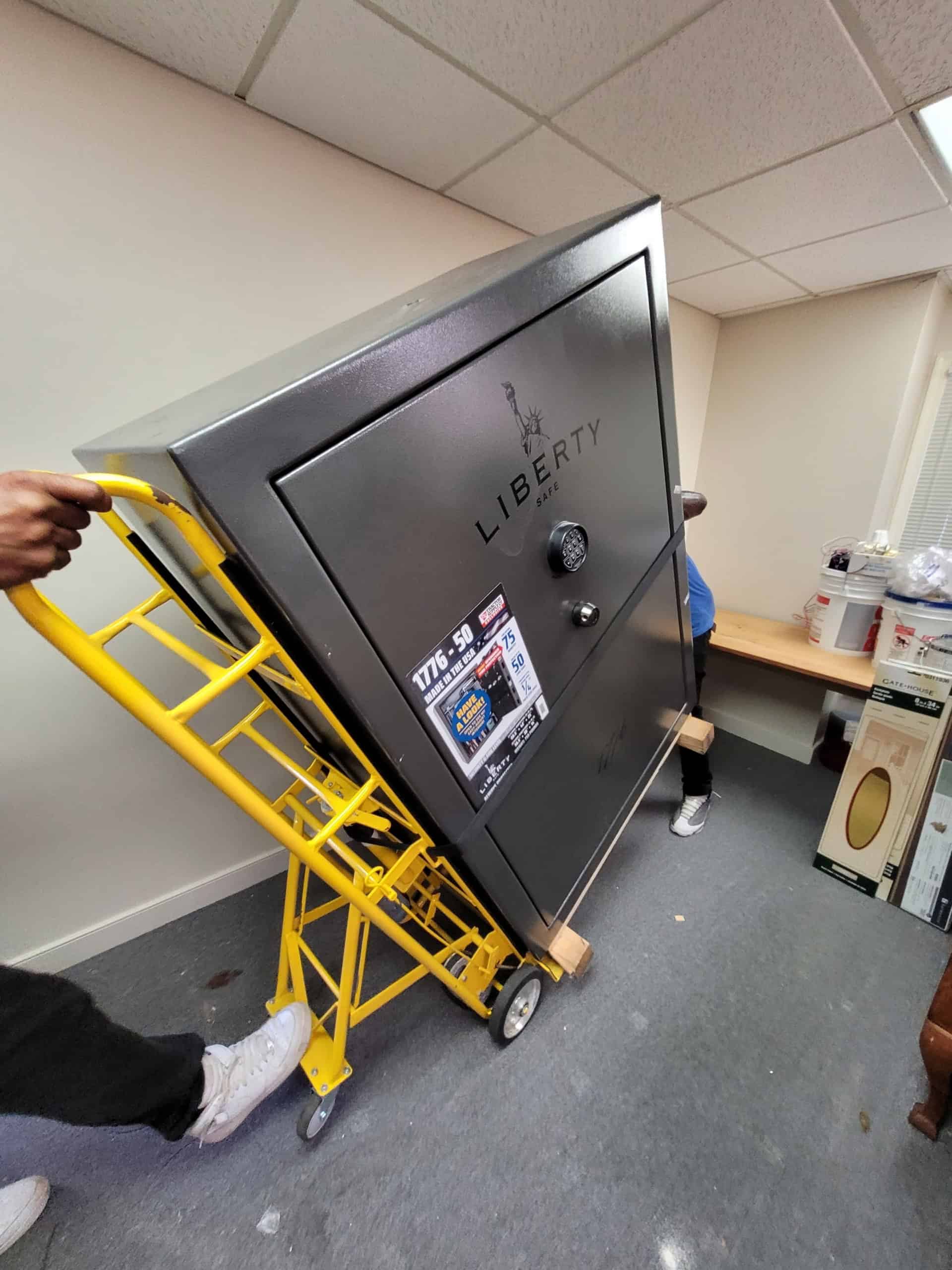 two members of STAR Movers moving a safe